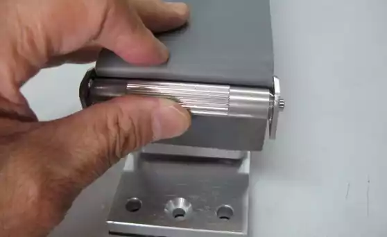 The screw on the other side is turned while pushing up the wedge roller by your finger and the tension is given to the sandpaper.